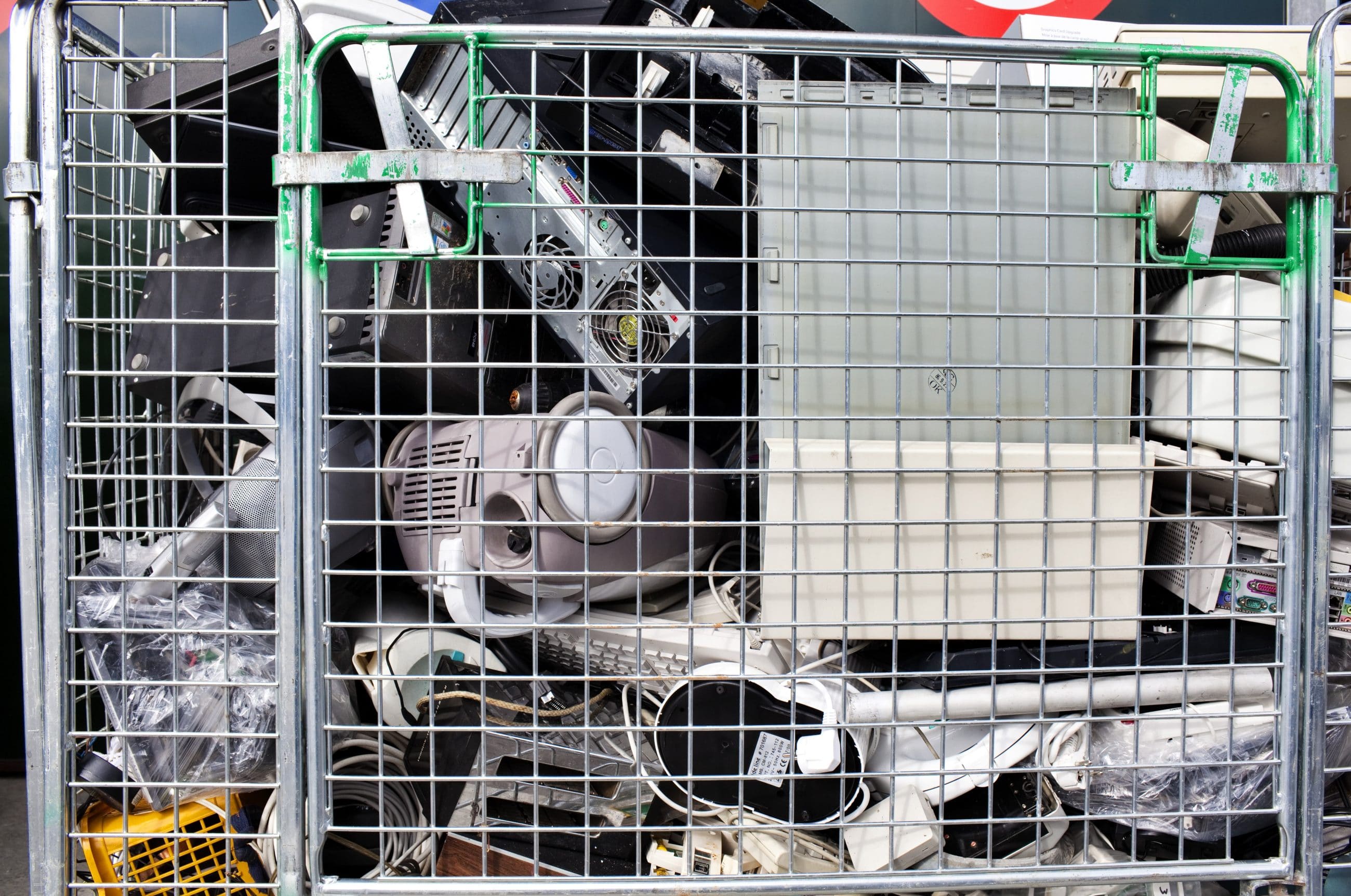 electronic waste in metal cage recycling bin